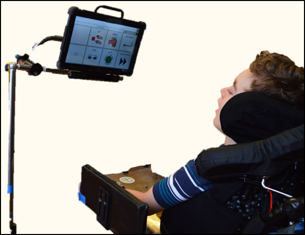 jeffrey, looking at the core vocabulary on a screen mounted to his wheel chair