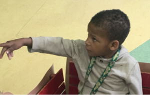 nathan, sitting in a wagon, pointing off to the side